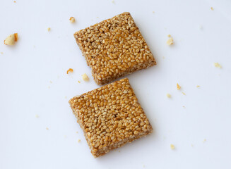 Til chikki on white background. Til chikki is an Indian sweets dishes made with jaggery and sesame. Indian festival Makar Sankranti special sweet.