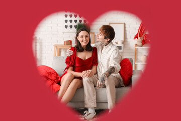 Young couple having date at home, visible through red heart. Valentine's day celebration