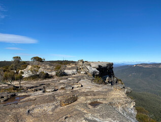Fototapeta na wymiar Views from a mountain-top lookout. Blue mountains, Australia, NSW. Rock formation and dry vegetation at the summit.