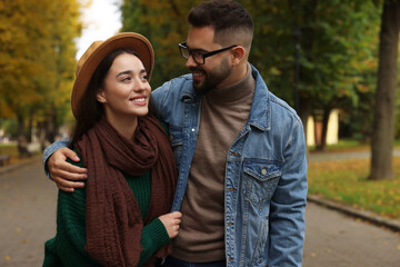 Happy young couple spending time together in autumn park