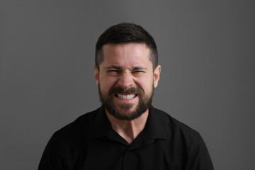 Personality concept. Angry man on grey background