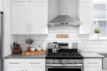 A kitchen detail shot with white cabinets, stainless steel appliances, granite countertops, and a...