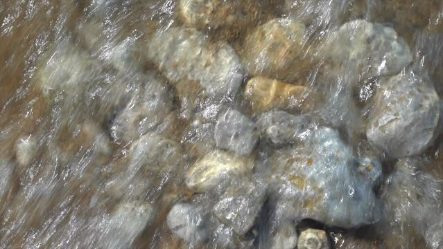 Cinematic shoreline Lake Michigan Petosky Stone rocky beachside peaceful dramatic state park Harbor Springs Mackinaw Island Up North summer daytime bright afternoon calm peaceful slow pan upward