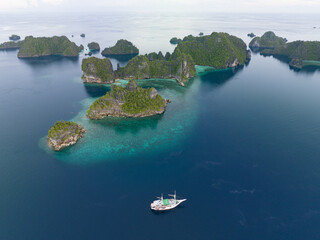 Rugged, limestone islands, fringed by reefs, rise from the scenic seascape in Raja Ampat,...