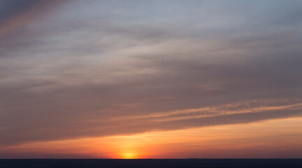 Landscape with bloody sunset. Panorama. Tragic gloomy sky. The last flashes of the sun on the storm clouds.