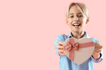 Cute little boy with gift for Valentine's day on pink background