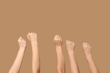 Female hands with clenched fists on beige background. Women history month