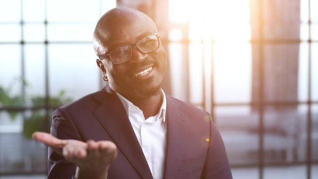 Male businessman in a suit stretching hand and showing a palm up gesture.