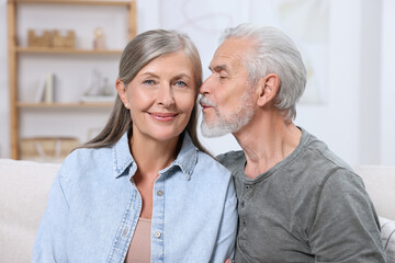 Senior man kissing his beloved woman indoors