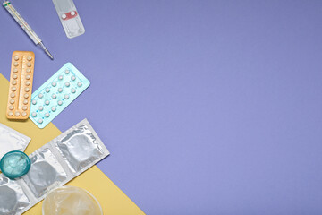 Contraceptive pills, condoms and thermometer on color background, flat lay with space for text. Choice of birth control method