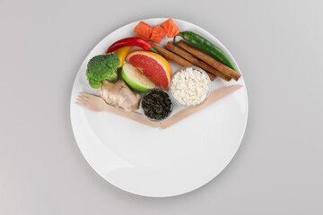 Metabolism. Plate with different food products and wooden cutlery on light grey background, top view