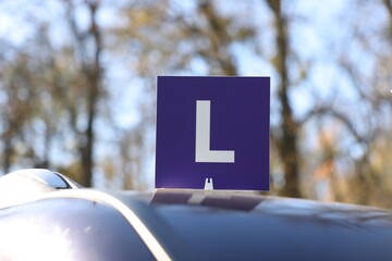 L-plate on car roof outdoors. Driving school