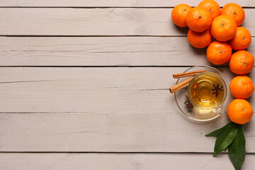 Sweet mandarins, star anise, cinnamon and cup of tea on grey wooden background
