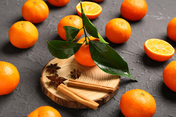 Sweet mandarins with cinnamon and star anise on black background