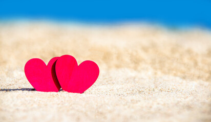 Fototapeta premium romantic symbol of two hearts on the beach 