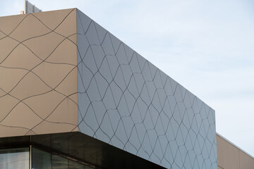 Commercial external metal composite panels on a building with blue sky and clouds in the...