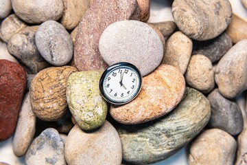 Clock with time on stones for the concept of relaxation or moving forward and motivation.