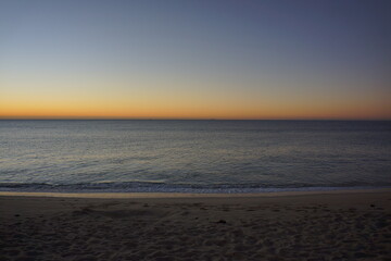 Naklejka premium Beach and ocean just before sunrise, sky turning bright
