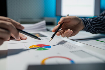 using computer together in office, successful business people working together in a co-working office, two business professionals working on a tech project, business colleagues talking to each other,