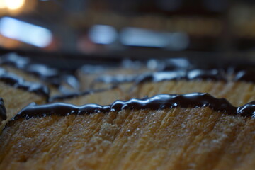 Macro of Spanish abanico drizzled in chocolate, in tray, in store, well lit