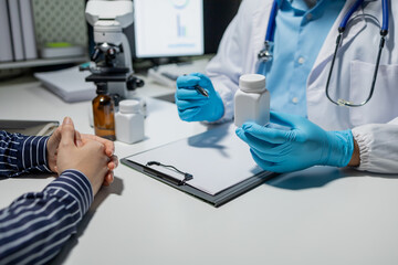 Doctor and patient in conversation about pill description, professional physician wearing white coat talking to mature woman signing medical paper at appointment,