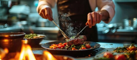 A chef cooking beef steak in a restaurant kitchen, using only hands and decorating with vegetables. - obrazy, fototapety, plakaty