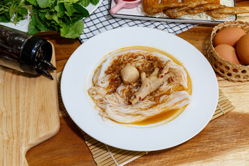 Rice noodles in fish and Anchovy curry sauce with chicken feet and vegetables. Thai cuisine