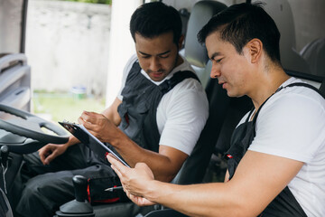 Mover workers an ethnically diverse team driving a truck for relocation service. Confidently...