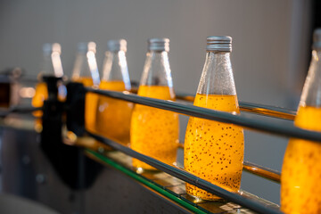 The beverage factory's automated bottling line efficiently fills transparent bottles with organic...