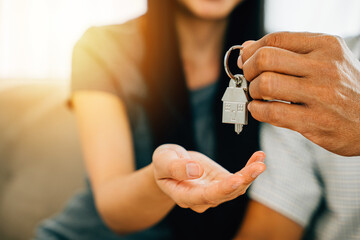 A delighted couple holding keys to their new home exudes joy and excitement in their real estate purchase. Reflecting happiness success and a new chapter in their lives. - obrazy, fototapety, plakaty