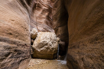 A huge  stone blocked the bed of a small stream flowing along the Wadi Numeira hiking trail in Jordan