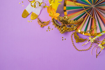 Carnival or mardi gras concept with golden carnival masks and party decorations on purple...