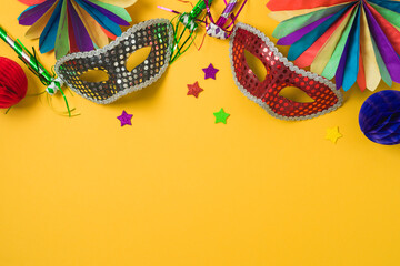 Carnival or mardi gras concept with golden carnival masks and party decorations on yellow...