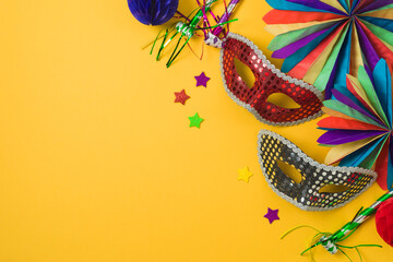Carnival or mardi gras concept with golden carnival masks and party decorations on yellow...