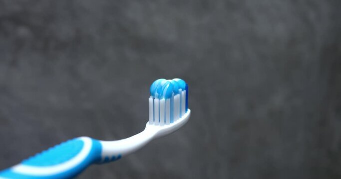 Applying toothpaste to toothbrush close up. Importance of brushing teeth daily in morning and evening. Products for cleaning teeth and keeping oral cavity clean tidy preventing tooth decay tooth pain