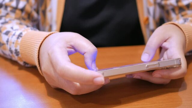 Close-up of an individual playing some online games using a smart mobile phone.