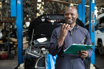 male worker talking on smartphone with customer in garage