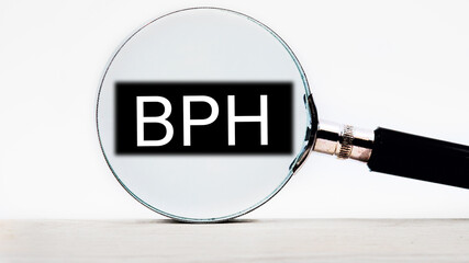 BPH Benign Prostatic Hyperplasia lettering on through a magnifying glass on a light background