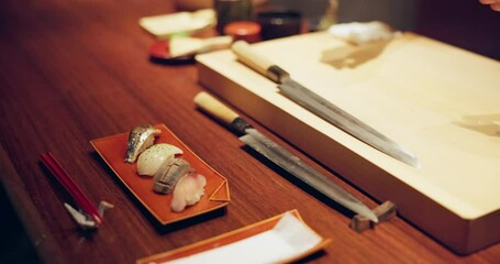 Hands, sushi chef and presentation in restaurant on table at diner, cuisine or expert cooking in night. Person, kitchen or fish with catering, plate and service for nutrition, diet or snack in Japan