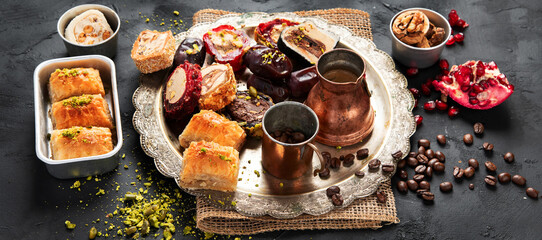 Hot tasty coffee with various pieces of turkish delight desets on a dark background. Traditional arabian food