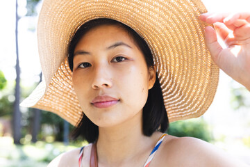 Portrait of asian woman with short hair wearing sunhat in garden at home