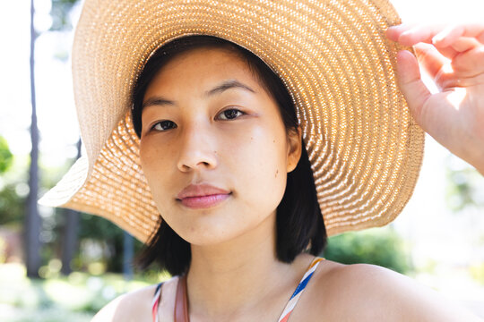 Fototapeta Portrait of asian woman with short hair wearing sunhat in garden at home