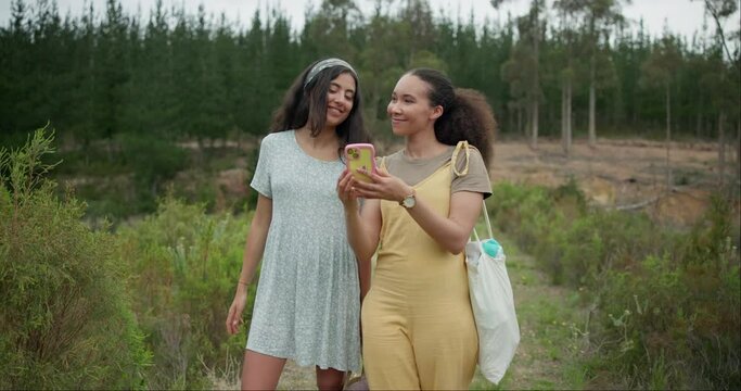 Happy woman, friends and phone in forest for social media, photography or pointing for natural outdoor scenery. Female person or people smile with mobile smartphone in nature or woods with trees