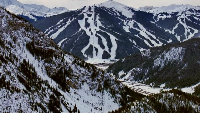 Ski runs trails Distant  i70 Copper Mountain Leadville Colorado Winter December Christmas aerial drone cinematic landscape Silverthorne Vail Aspen Ten Mile Range cloudy Rocky Mountains forward reveal
