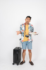 A confused Asian man in summer clothes is getting lost during his summer vacation trip, using a map.