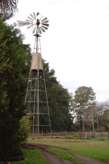 A windmill in the countryside next to a road