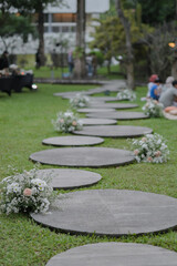 Rounded concrete for walking pedestal in the garden arranged with flowers. Wedding ceremony....