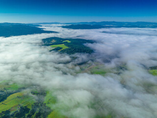 Lot nad Jastrzębikiem w mglisty poranek latem. Widok znad chmur. - obrazy, fototapety, plakaty