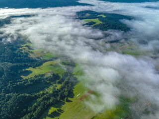 Lot nad Jastrzębikiem w mglisty poranek latem. Widok znad chmur. - obrazy, fototapety, plakaty