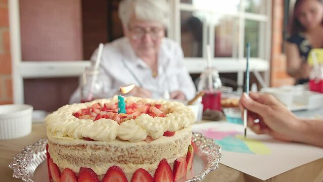 Strawberry shortcake with candle in focus as birthday party of women water color at table